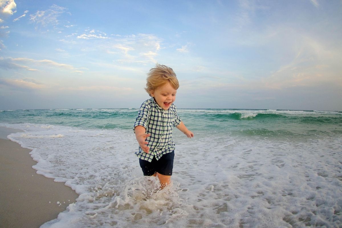 child makes a splash at the beach in Destin during a photo session